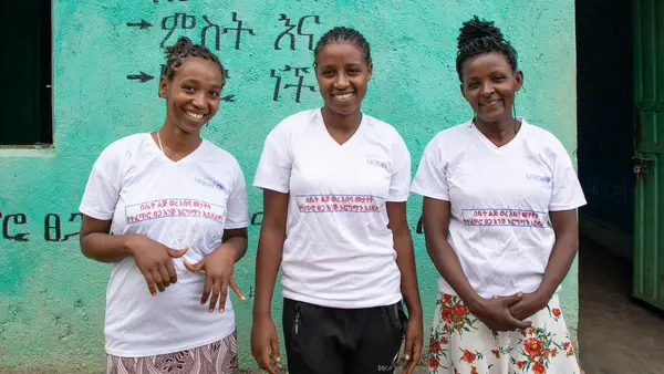 Three members of the gender club at Anka Primary School in SNNP region, Ethiopia, wear T-shirts that read, "Women's menstruation is not a curse but rather a natural gift."