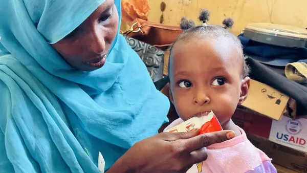 A child with severe acute malnutrition eats Ready-to-Use Therapeutic Food after a nutrition screening organized by UNICEF and partners in Sudan's Kassala state on May 24, 2023.