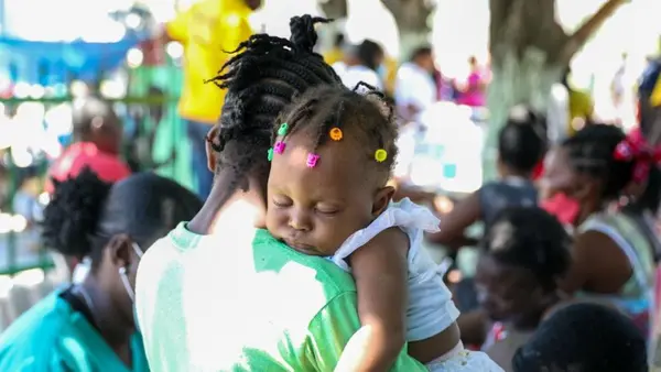 A girl sleeps on her mother’s shoulder at a mobile clinic organized by UNICEF and the Ministry of Health for families displaced due to violence in Cité Soleil, a neighborhood of Port-au-Prince, Haiti.