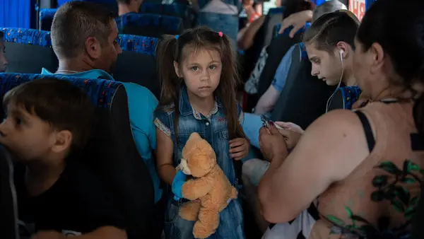 On June 7, 2023, 7-year-old Anya and her family evacuate by bus from Kherson following the collapse of the Kakhovka dam. 