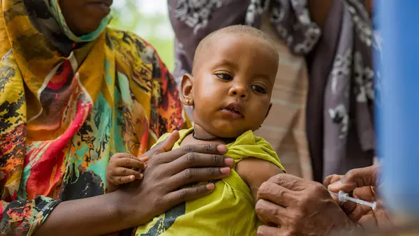 On June 5, 2023, Ibtisam Abdullah, a vaccinator at Gezirat Al-Feel Health Center in Sudan vaccinates a child at a shelter for displaced people.