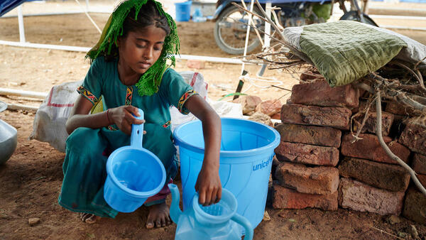 8-year-old Geetu of Umerkot, Sindh province, Pakistan, organizes items that came with the hygiene kit her family received from UNICEF as part of emergency relief to families impacted by the summer 2022 floods.