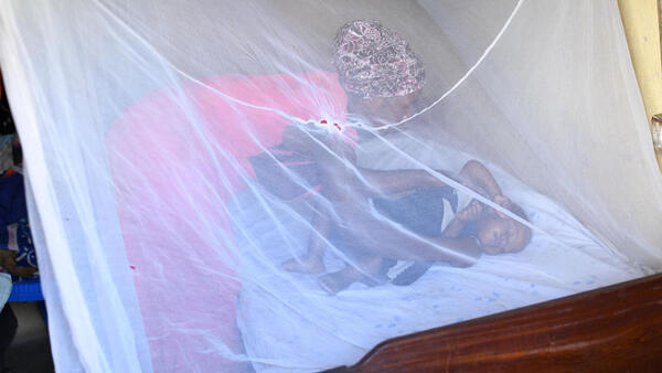 A mother puts her baby to sleep under an anti-malarial bednet provided by UNICEF at their home in Kabingo village, Ntungamo district, Uganda.