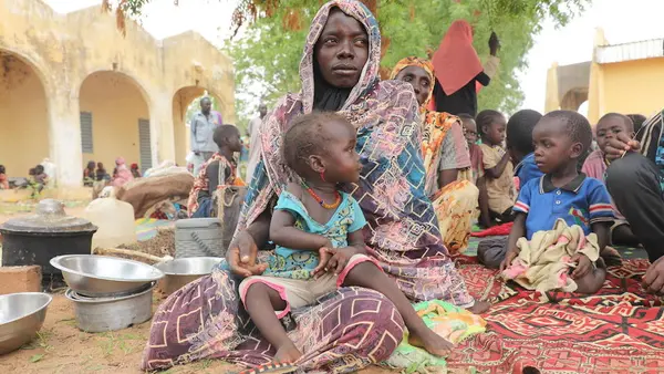 On June 17, 2023, Mariam Djimé Adam, 33, sits in the yard of a secondary school in Chad. She arrived from Sudan the previous day with her eight children.