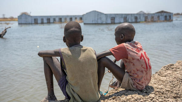 Two boys look out at their flooded school in Bentiu, Unity State, South Sudan, an area that suffered extensive flooding, an impact of climate change.