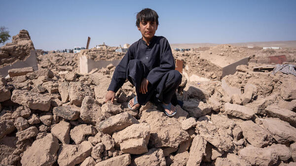 Eleven-year-old Milat sits in the rubble of his home in Injil district, Afghanistan on Oct. 11, 2023 after one of several earthquakes that hit Herat Province that month.