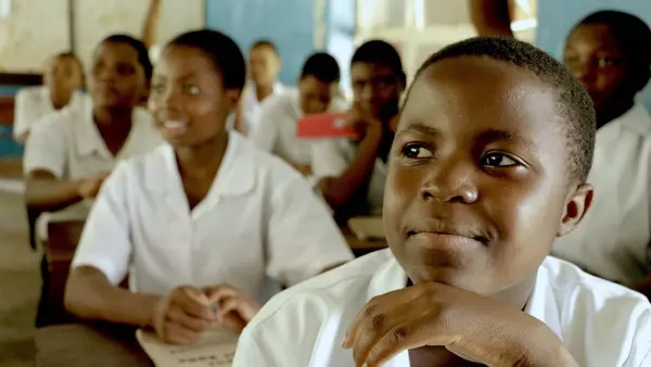 Joyce Chisale smiles as she sits in a classroom at St. Michaels Girls Secondary School in Mangochi, Malawi, after receiving her scholarship through the K.I.N.D. Fund.