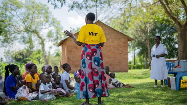A UNICEF-supported community mobilizer prepares community members for a vaccination drive in Uganda.
