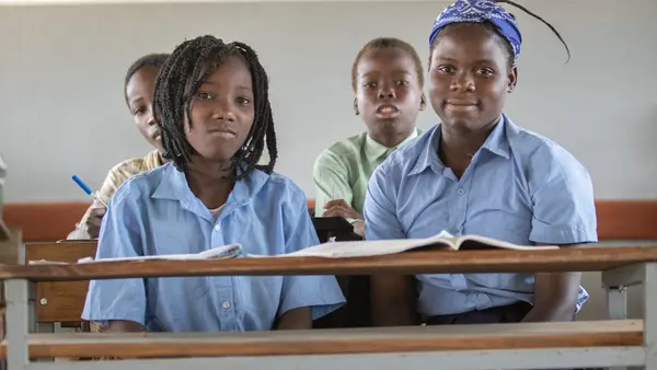 In Mozambique, Josefa, 14, left, and Margarida, 15, sit together in class at Primeiro de Junio Primary School in Buzi district, Sofala province, a climate-proof school constructed as part of UNICEF’s climate-resilient infrastructure program in the country.