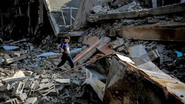 Mohammed, 9, walks over the rubble of his destroyed home on Omar Al-Mukhtar Street in Gaza City on Jan. 11, 2024.