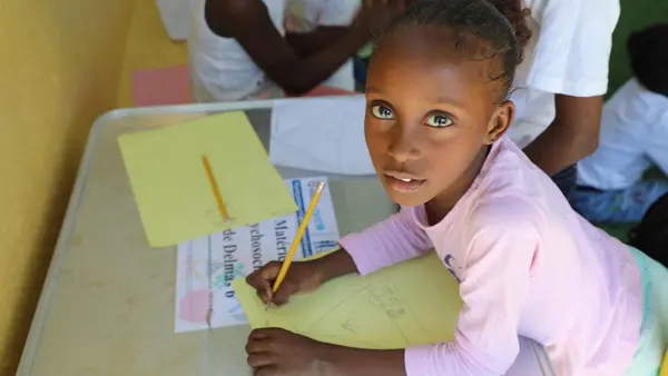 Seven-year-old Lovenska of Haiti works on a drawing at a UNICEF-supported child-friendly space in Delmas 6, downtown Port-au-Prince.
