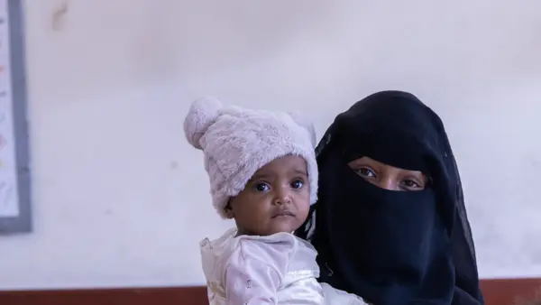 Married at 12, Yousra, 16, holds one of her two daughters in Taizz, Yemen. 