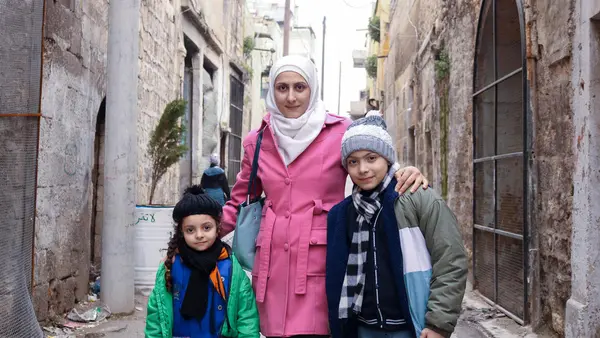 Sara, 5, and Waed, 12, with their mother Bushra outside a UNICEF-supported child protection center in Maysalun neighbourhood, Aleppo city, Syria, on Feb. 8, 2024.