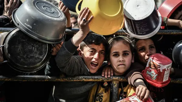Mohammad, 11, and Reham, 9, stand at a food distribution center in Rafah, southern Gaza Strip.