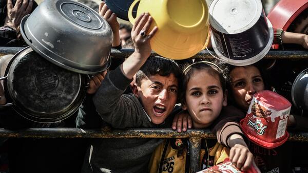 Mohammad, 11, and Reham, 9, stand at a food distribution center in Rafah, southern Gaza Strip.
