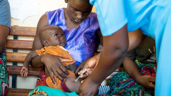 A community health worker administers the malaria vaccine to a child at Chileka Health Center in Lilongwe district, Malawi.