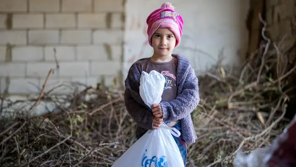 Amar, 5, holds a bag of supplies delivered by UNICEF to displaced families from South Lebanon in December 2023.