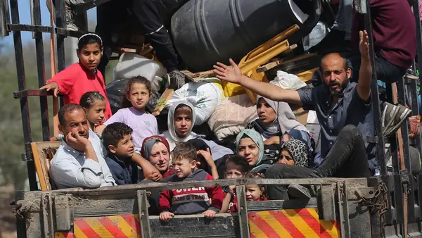 Children with their families sitting in the back of a truck during their displacement from areas witnessing an escalation in hostilities in Rafah, south of the Gaza Strip.
