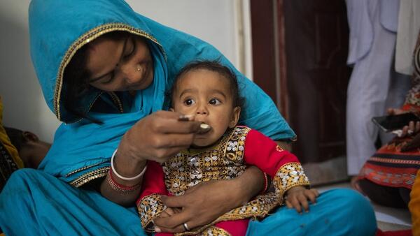 A mother feeds her 10-month-old daughter at a UNICEF nutrition counseling session on complementary feeding on Feb. 29, 2024, in Lyari, Karachi, Sindh, Pakistan. 