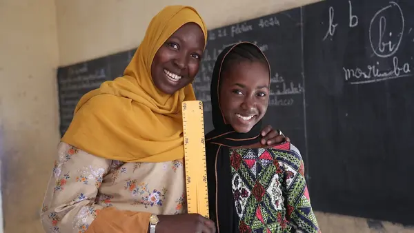  A UNICEF-supported teacher and one of her students stand in front of the chalkboard at a school in Mali.