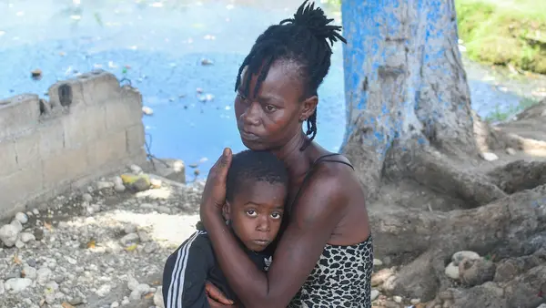 A mother holds her child close in Haiti, where escalating violence is pushing more and more families from their homes. 