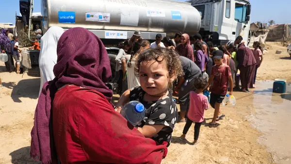 Aseel, one-year-old, holding a bottle of water filled from a UNICEF-supported water tank in Deir al-Balah, in the Gaza Strip, thanks to the government of Australia and Sweden.