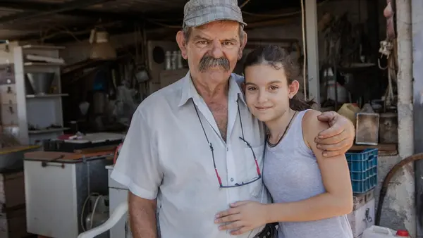 Markos Sakarikos, 70, a pensioner and a beekeeper from Nea Makri, Greece, with his granddaughter Markela..