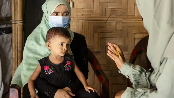 On July 15, 2024, UNICEF-trained Rohingya community nutrition volunteer Taslima visits Noor Bibi, 28, to provide nutrition counseling and to assess the nutritional status of her daughter Jishan, 2, at their shelter in the Rohingya refugee camps in Cox’s Bazar, Bangladesh.