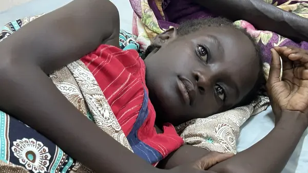 Narmin, 10, lies in a bed at Al Nau hospital in Khartoum where she is being treated for an injury suffered during a shelling.
