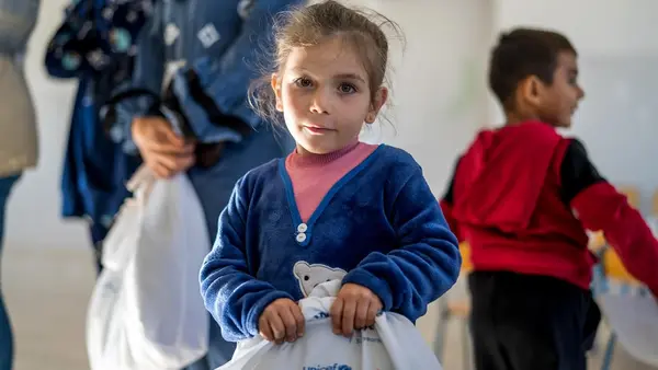 A girl holds a UNICEF winter clothing kit in southern Lebanon. 