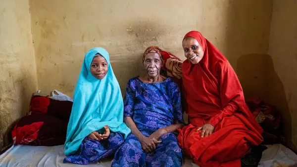 Fatima Habibu, 99, sits with her granddaughter, right, a volunteer community mobilizer, and great-granddaughter in Katsina, Nigeria.