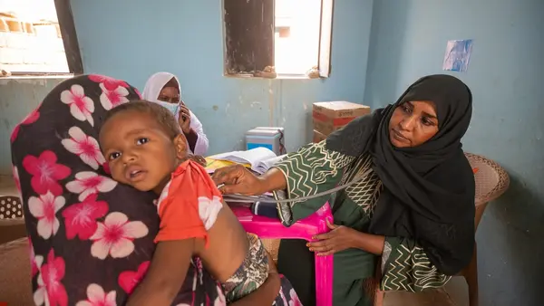 A mother brings her child for treatment at a UNICEF-supported mobile clinic in Adama locality, Atbara, River Nile state, Sudan. 