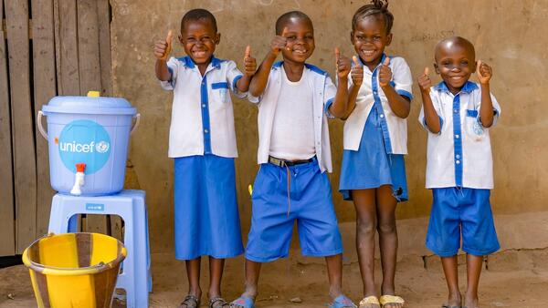 Students at Ecole Primaire Ilako in Mbandaka, Democratic Republic of the Congo, stand outside their classroom after washing their hands. UNICEF installed handwashing stations at the school to help students protect themselves from Ebola.