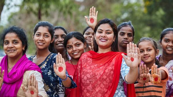 Payal Patel, who has developed a basket of affordable and sustainable menstrual products for women, poses with women and girls in Odisha, India.