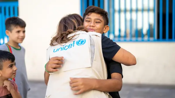 Mohammad, 13, is comforted by a UNICEF staff member outside a shelter in Beirut for families displaced by war.