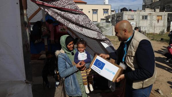 UNICEF Staff members distribute warm clothing to the IDP community in Rafah, southern Gaza Strip.