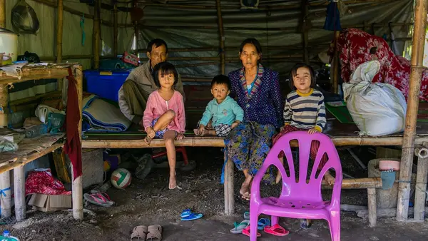 A family displaced by conflict in Kachin State, Myanmar, sits inside their makeshift room at the Shamari IDP camp in Myitkyina, where Deputy Executive Director Ted Chaiban paid a visit to witness impacts of the ongoing humanitarian crisis in the country.