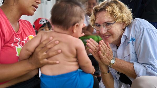 Karin Hulshof, UNICEF Regional Director in Latin America and the Caribbean, plays with a baby at a respite center for migrating families in Darien, Panama.