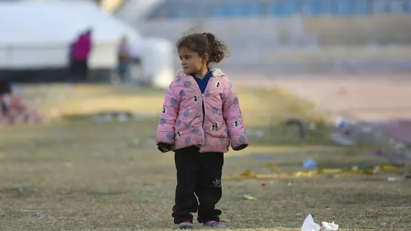 On Dec. 4, 2024, in Ar-Raqqa city, Syria, a young girl stands outside a UNICEF-supported reception center for families displaced by escalating violence in Aleppo.