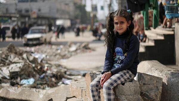 An 11-year-old Palestinian girl sits on the rubble of a house in the Gaza Strip.