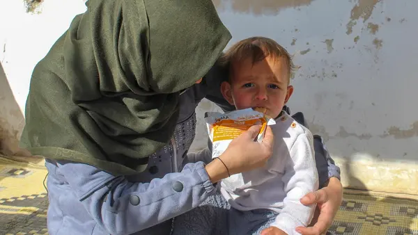 In Obada village, Rural Damascus, Syria on Dec. 17, 2024, a mother feeds her 1-year-old son a preventive food supplement distributed by UNICEF.