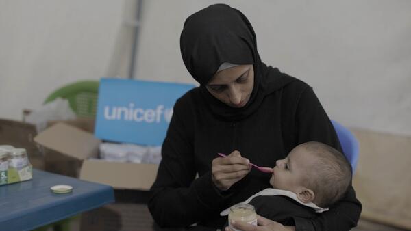A mother feeds her baby supplementary food at a UNICEF nutrition point in Gaza City. 