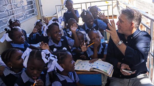 In Port-au-Prince on Jan. 27, 2025, UNICEF Global Spokesperson James Elder interacts with students during a visit to a school that UNICEF and partners relocated from La Saline in 2023, after students got caught up in a clash between two armed groups.
