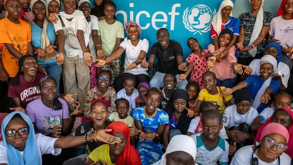 On Jan. 29, 2025, in Kolda, Senegal, members of the local girls club pose for a photo  during a visit from Khaby Lame (center rear, in black shirt). 