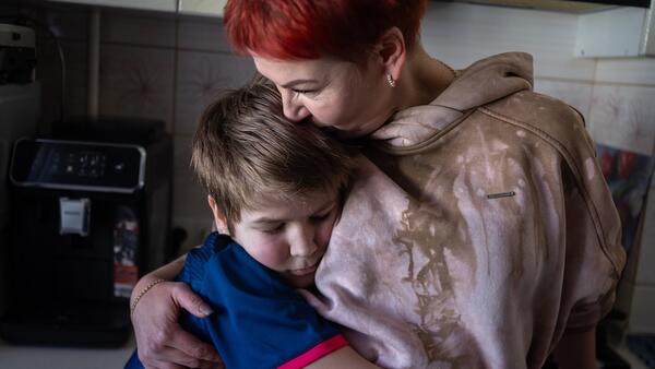 Ten-year-old Andrii embraces his mother in their kitchen in Kherson, eastern Ukraine. The boy has known nothing but war.