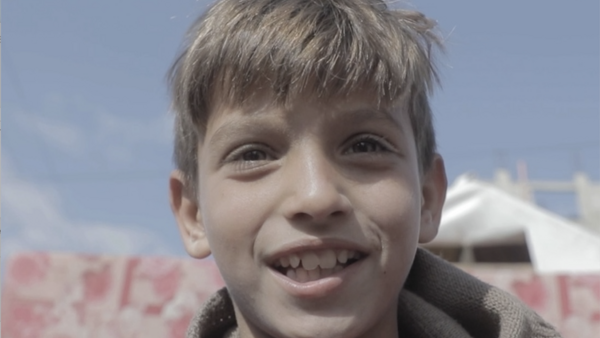 A boy stands outside his family's tent in the Gaza Strip. 