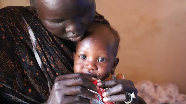In Renk, Upper Nile State, South Sudan, mother feeds her child from a packet of ready-to-use therapeutic food (RUTF) supplied by UNICEF to treat malnourished children.