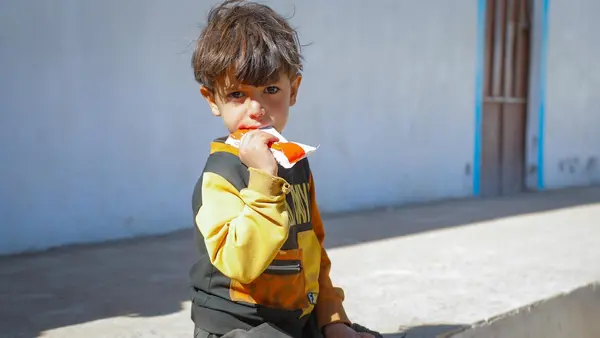 A malnourished child eats Ready-to-Use Therapeutic Food after being screened and diagnosed at the UNICEF-supported mobile clinic in Dhamar, Yemen.