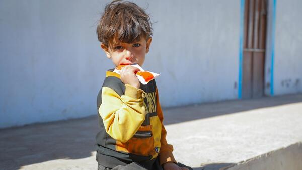 A malnourished child eats Ready-to-Use Therapeutic Food after being screened and diagnosed at the UNICEF-supported mobile clinic in Dhamar, Yemen.
