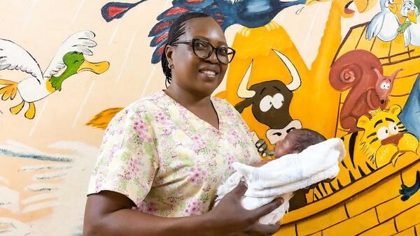 Nurse holding infant in neonatal department in Central African Republic 